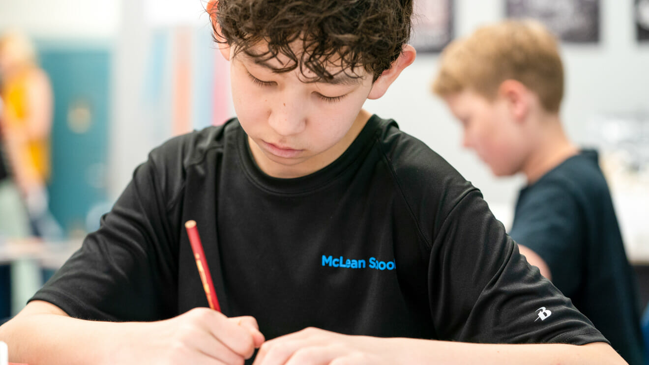 Boy focuses on writing in class