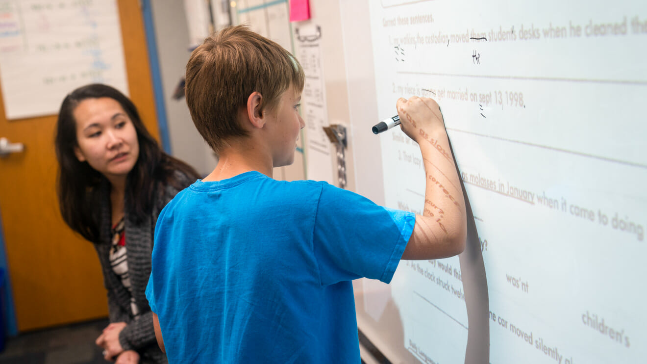 Boy writes on whiteboard