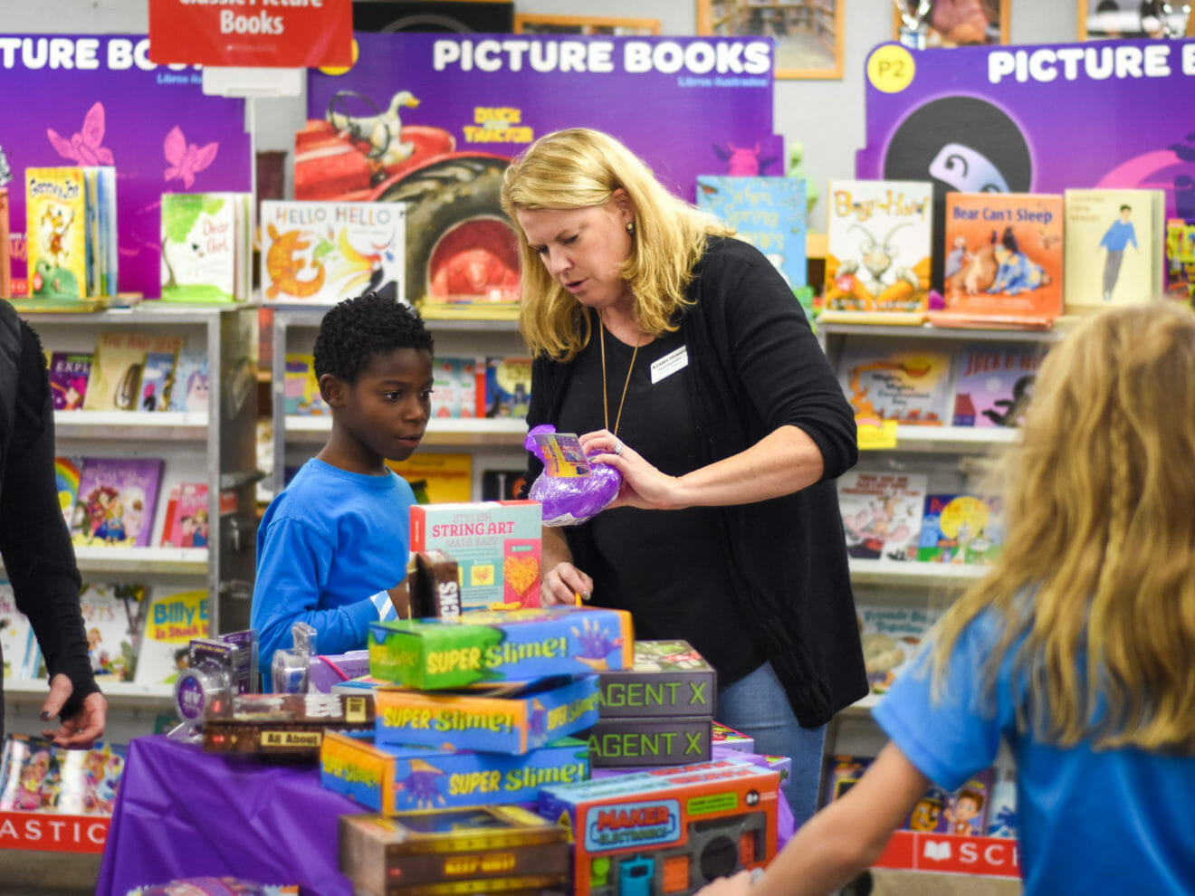 Volunteering parent helps student at book fair
