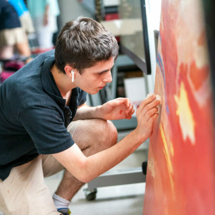 Student works on large painting