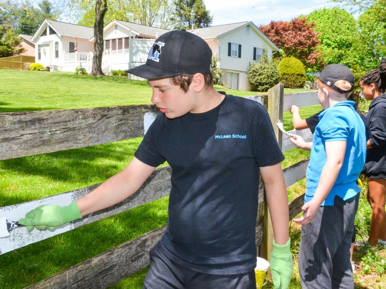 Middle school students paint fence for community service
