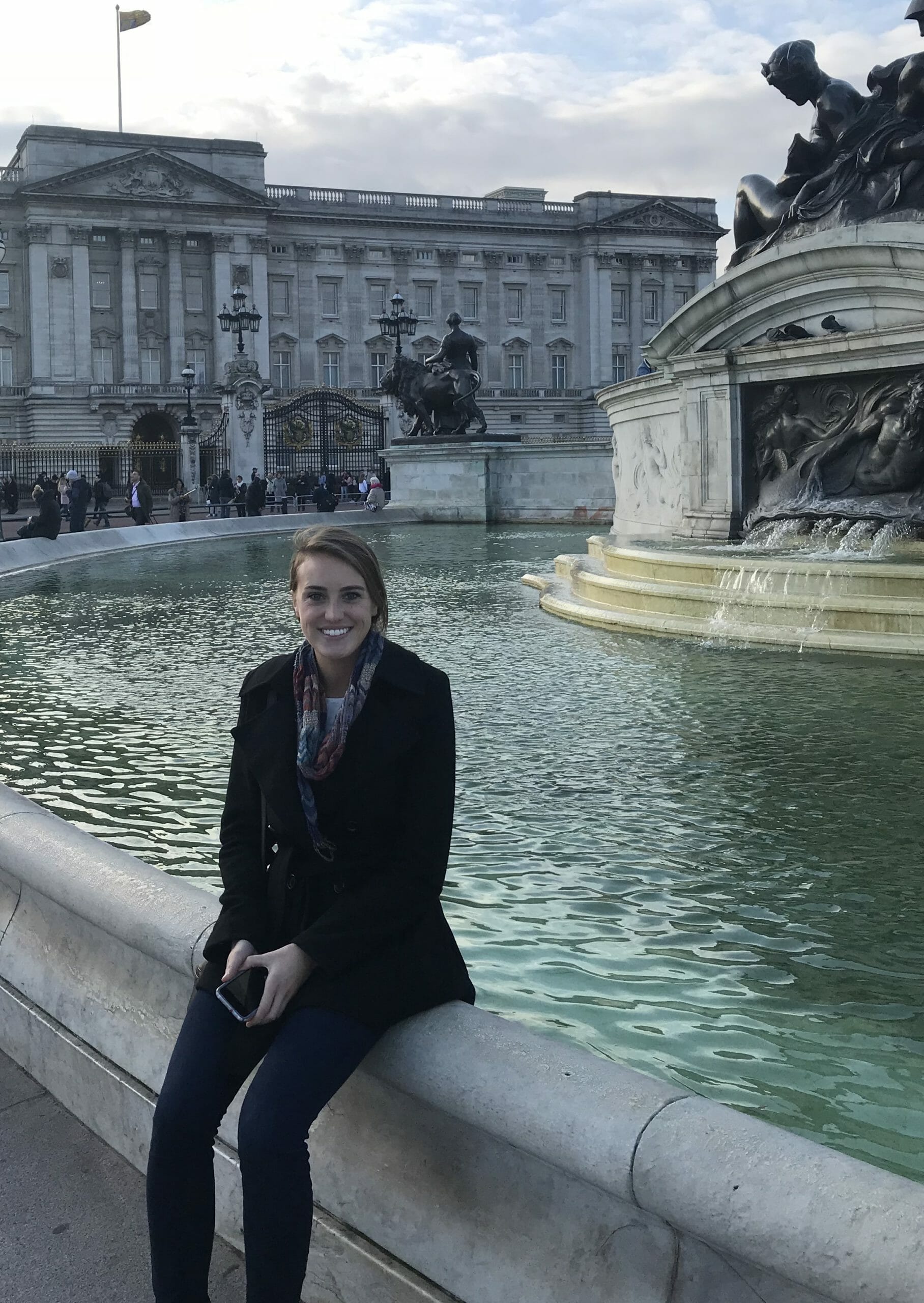 Kara Barber, 5th grade teacher at McLean School, smiles at the camera sitting next to fountain