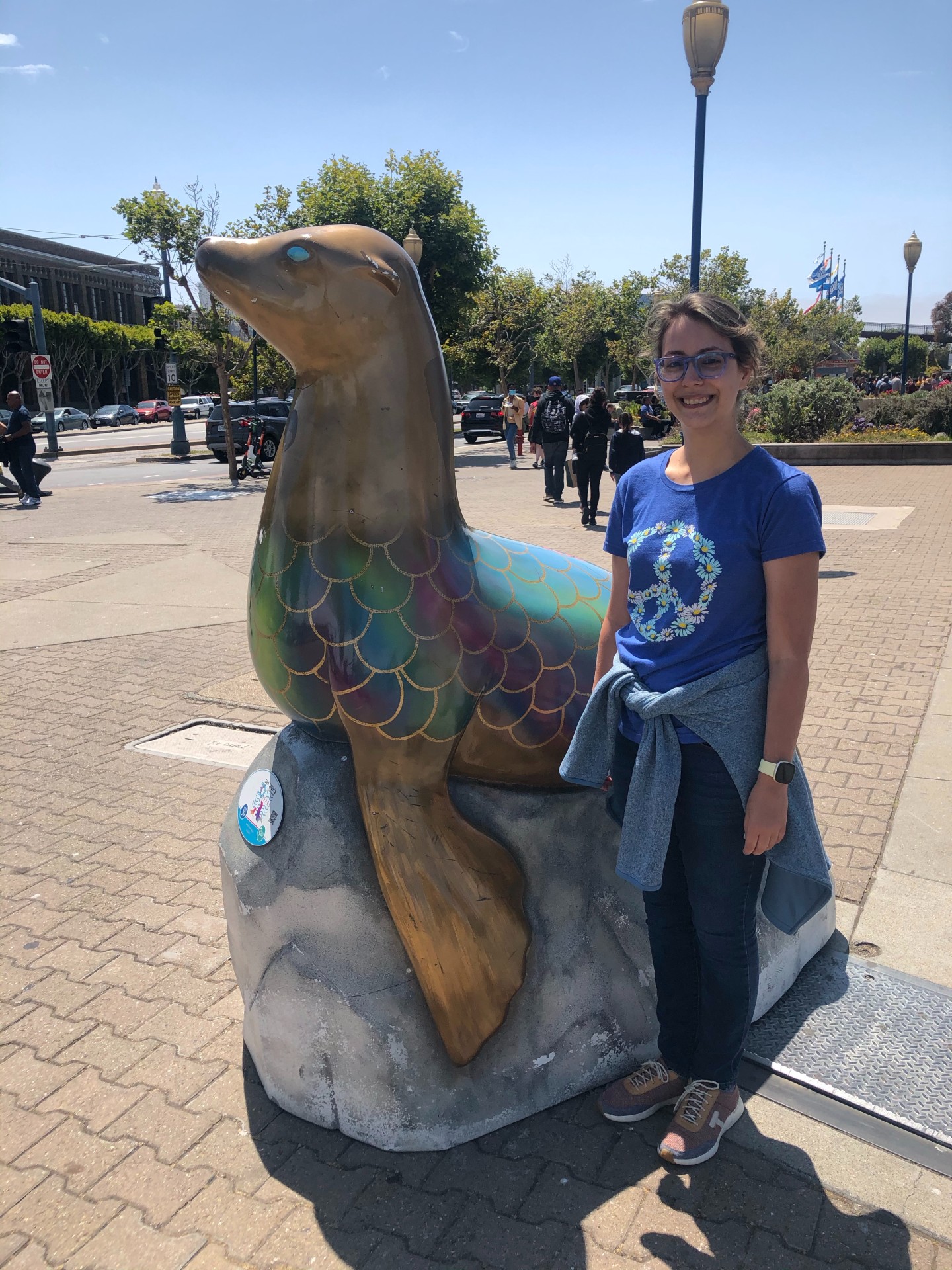 Stephanie Krause, Latin Teacher at McLean School, smiles at camera next to a sea lion statue