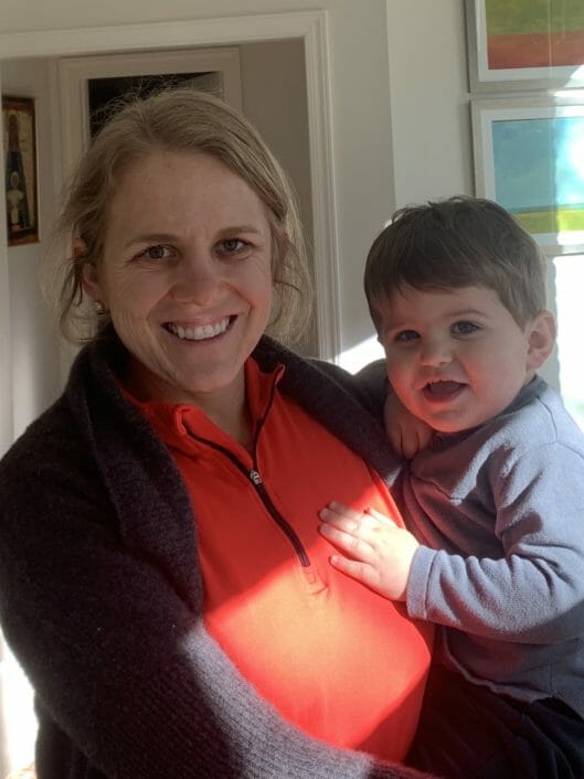 Mary Kathryn Netherton, kindergarten teacher, holds toddler and smiles at camera