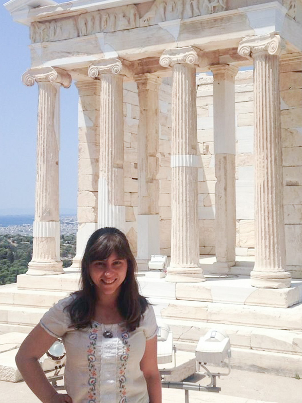 Talia Chicherio, a Latin teacher at McLean, posing in front of ancient Greek columns in Athens