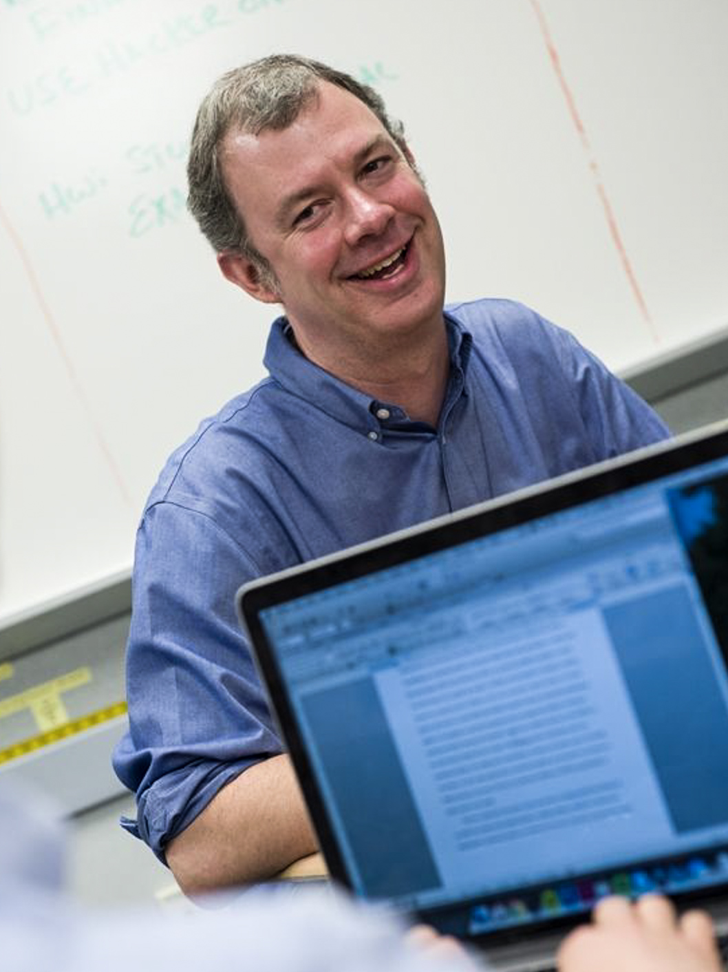 Bill Dunn, the History Department Chair at McLean, smiling while teaching a lesson