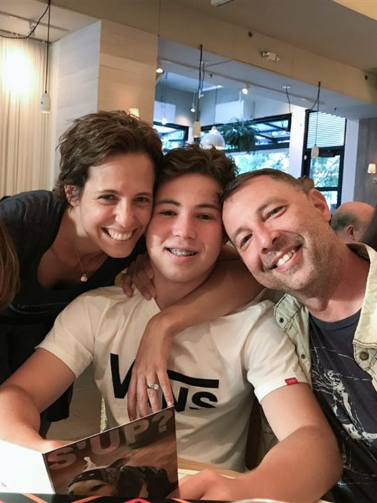 Brett Kluetz, a speech pathologist at McLean School, smiling with family in a restaurant