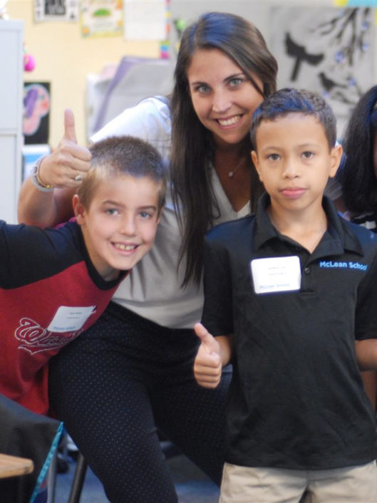 Brittani Ogransky, Grade 4 teacher at McLean School, smiles with two students