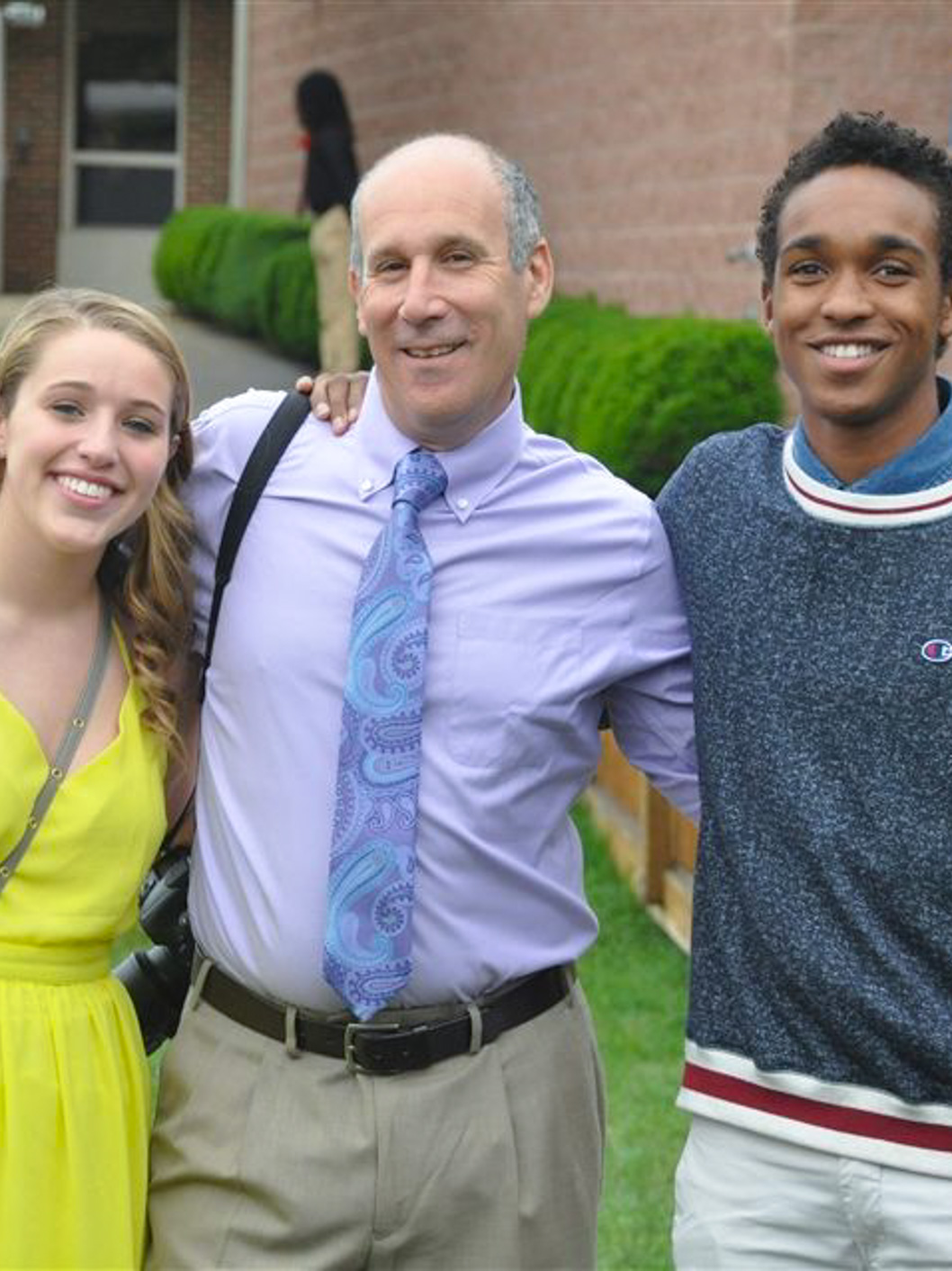 Andrew Ship, Upper School Counselor at McLean School, smiles at camera with students