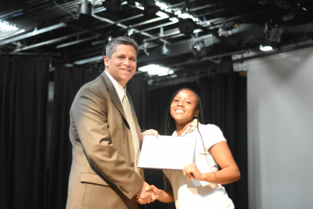 Head of Middle School, David Roth, gives award to Middle School girl