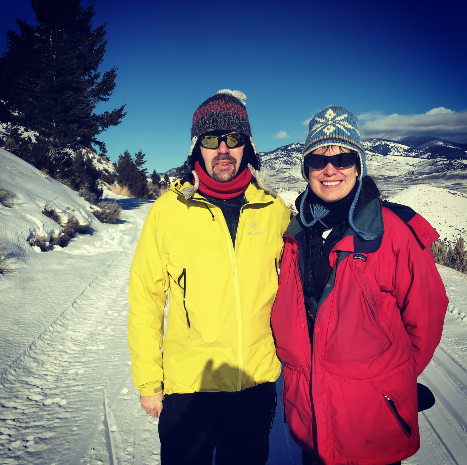 Christopher Childs, STEM Teacher at McLean School, poses for picture on a snowy hill in a yellow winter coat