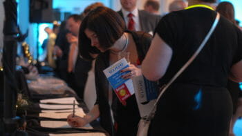 a woman filling out a form at a low table at a McLean event