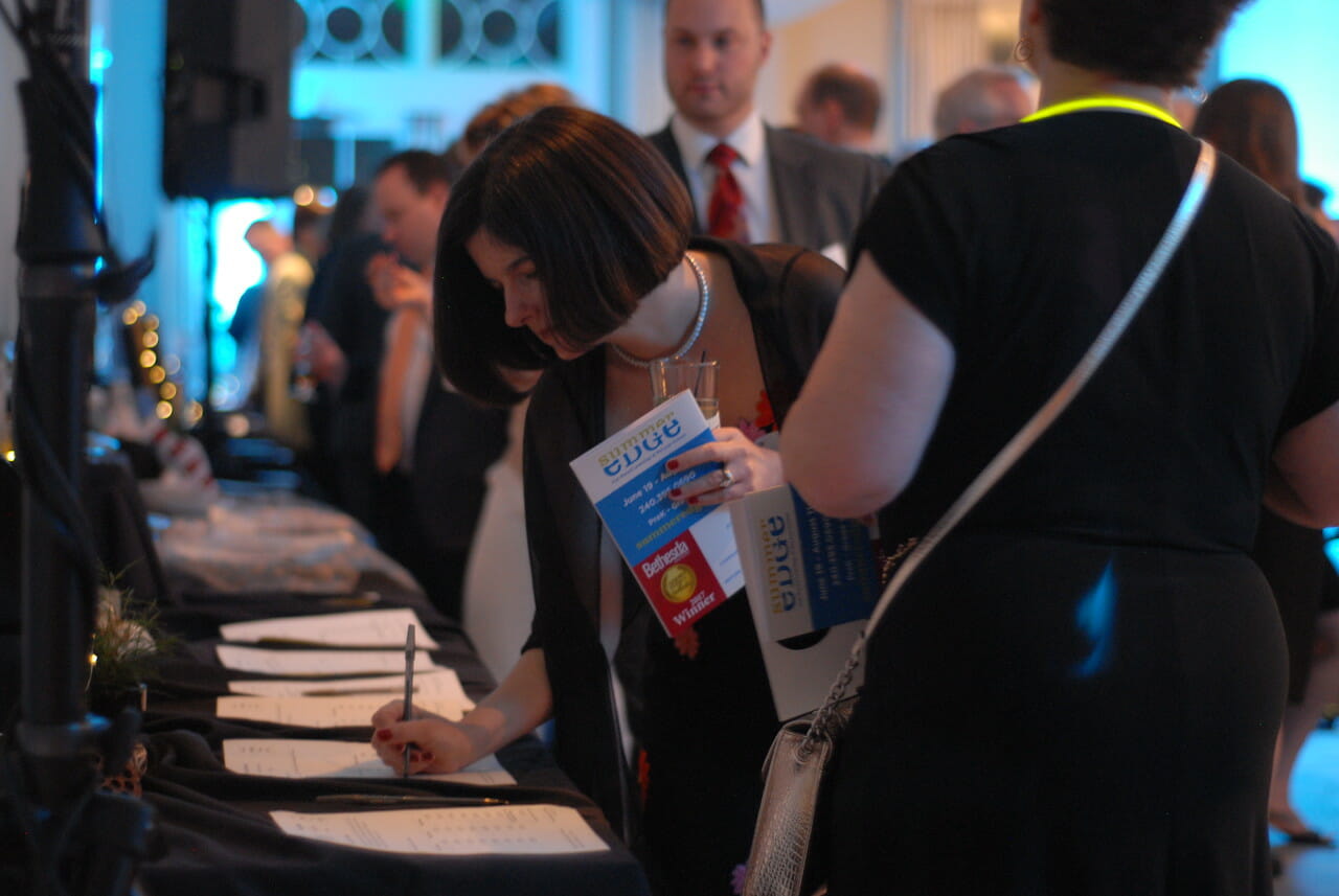 a woman filling out a form at a low table at a McLean event