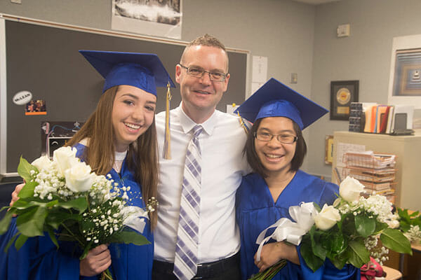 Greg-Schneider with two students at Graduation