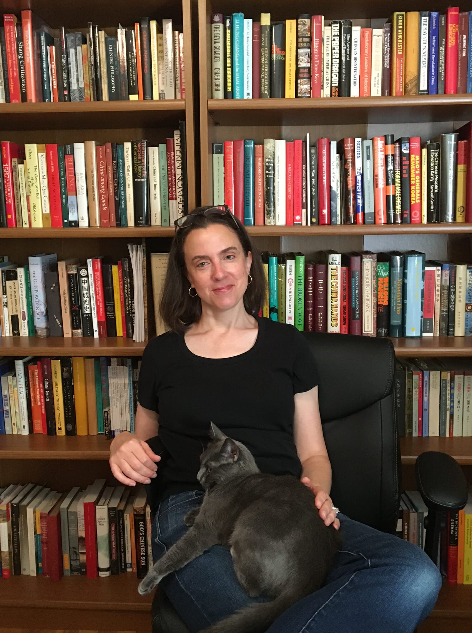 Julie Painton, Assistant Coordinator of Learning Services Academic Coach in the Upper School at McLean School, smiles for the camera with a cat on her lap
