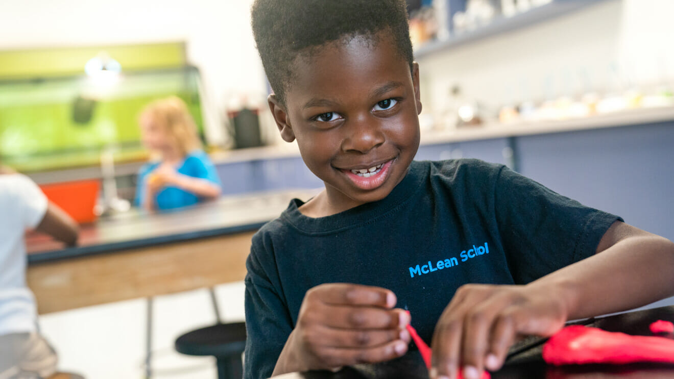 Smiling student works with putty