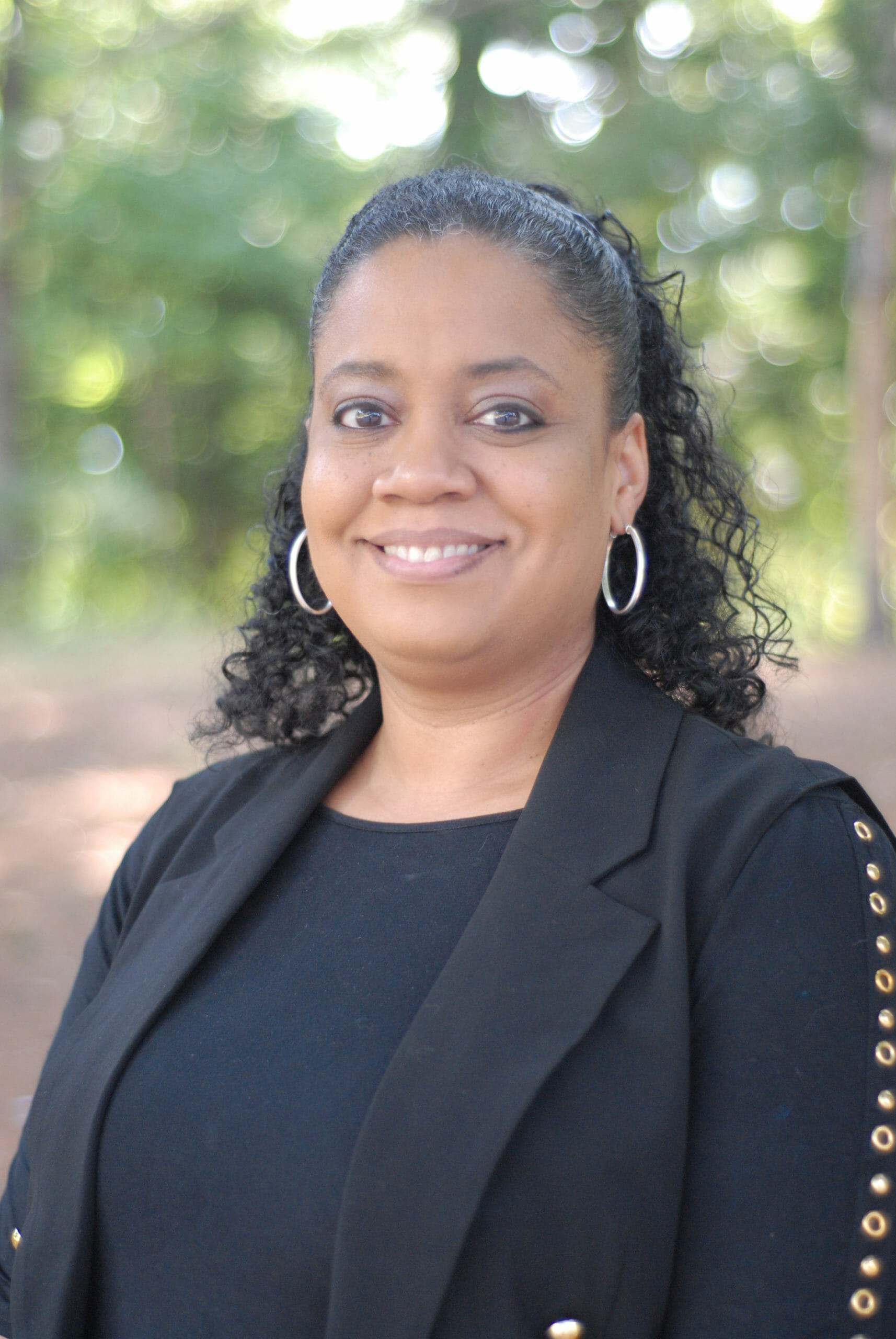 Robin Speller, Executive Support Manager at McLean School, smiles at camera while outside