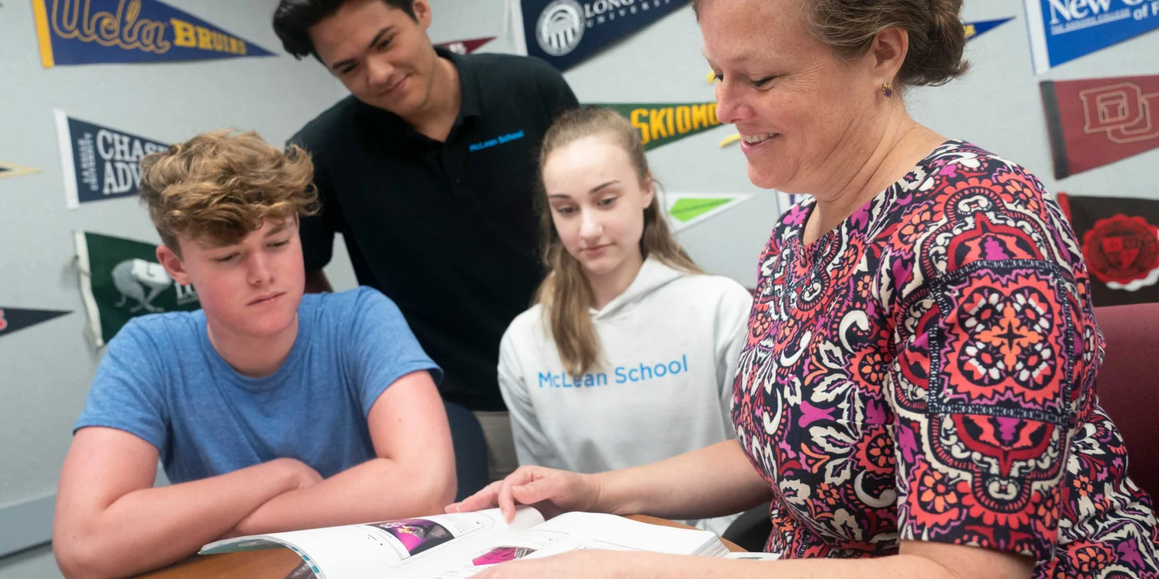 A woman reading a book with students.