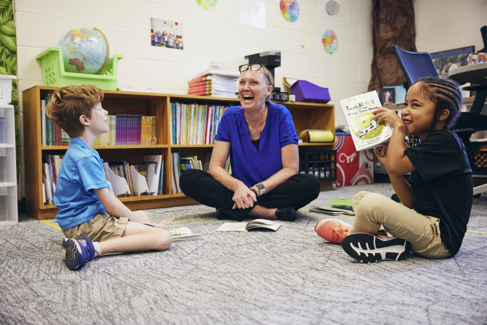 A teacher smiling alongside her students.