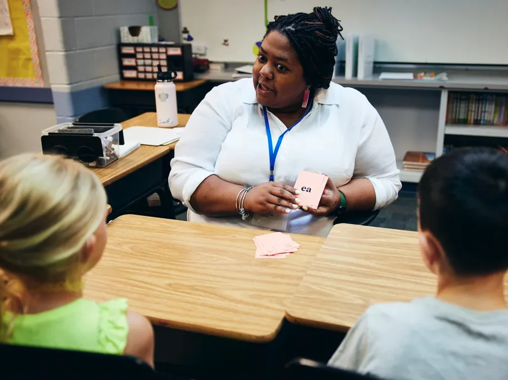 A teacher with students in a classroom.