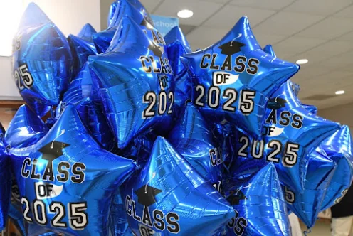 A cluster of blue star-shaped balloons with "Class of 2025" and a graduation cap printed on them.