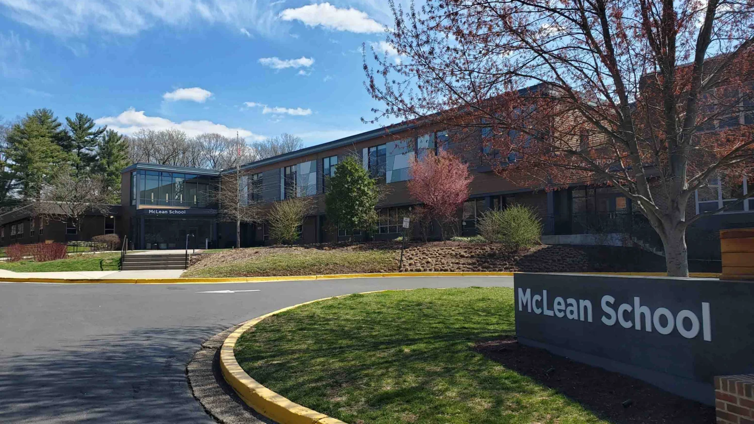 The exterior of McLean School shows a two-story brick building with large windows, trees, and a sign reading "McLean School" near a curved driveway on a clear day.
