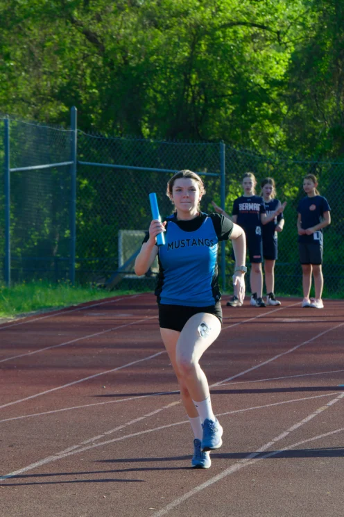 A young girl running track and field.